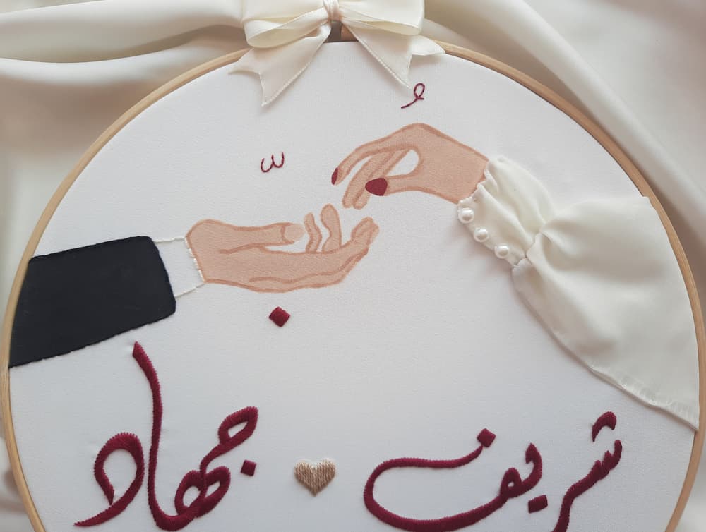 Embroidered engagement hoop with two hands forming (love) in Arabic
