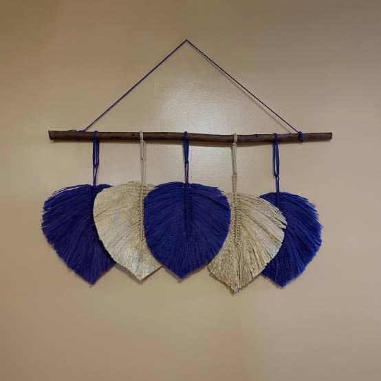 A macrame feather pen hanging on the wall 