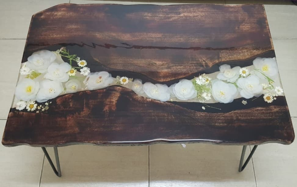 Epoxy table made with natural wood and artificial flowers